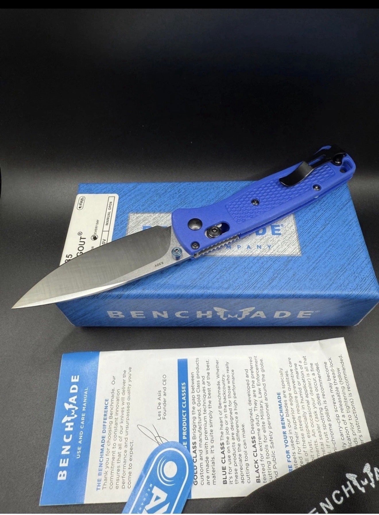 Benchmade knife with blue handle and blade on a black background
